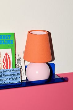 a table with a lamp, books and a bookend on the shelf next to it