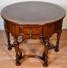 a round wooden table sitting on top of a hard wood floor