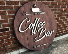 a wooden sign that says coffee bar next to a brick wall