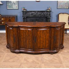 a large wooden cabinet sitting on top of a hard wood floor next to a fireplace