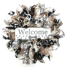 a welcome sign is hanging on a door with dog paws and bone print ribbon