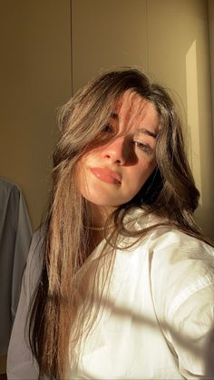 a woman with long hair is looking at her cell phone