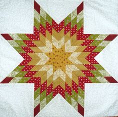 a red and yellow star quilted on top of a white table cloth with polka dots