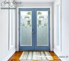 a blue front door with two glass panels and a rug on the floor next to it