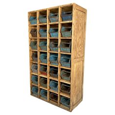 a large wooden storage unit with lots of blue bins on the front and sides