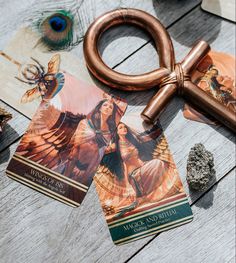 a pair of scissors sitting on top of a table next to cards and a rock