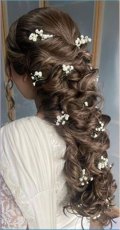 the back of a woman's head, with flowers in her hair and long curls