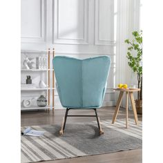 a blue chair sitting on top of a wooden floor next to a white and gray rug