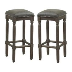 a pair of stools with grey leather upholstered seats