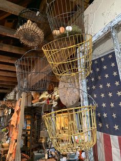 several bird cages hanging from the ceiling in a room with an american flag on the wall