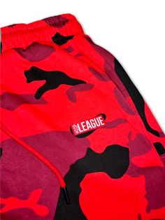 Hoop League Red Camo Streetwear Game Shorts Introducing Hoop League's Red Camo Streetwear Game Shorts. These shorts are made of lightweight, breathable fabric, with a red and gray camouflage pattern to keep you cool and stylish for any game. The drawstring waistband ensures a secure, comfortable fit. Get ready to dominate the court in these stylish, athletic shorts. Red Cotton Athletic Shorts For Streetwear, Red Cotton Athletic Shorts For Sports, Red Cotton Sports Pants, Red Athletic Shorts For Sportswear, Sporty Camouflage Cotton Bottoms, Casual University Red Shorts For Streetwear, Red Gym Bottoms With Elastic Waistband, Red Shorts With Elastic Waistband For Streetwear, Red Athleisure Athletic Shorts For Streetwear