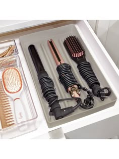 an open drawer with hair brushes and combs