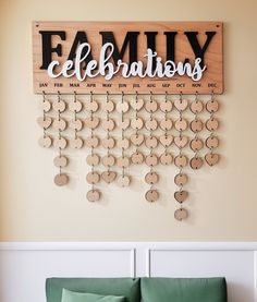 a family celebration sign hanging on the wall above a green couch in a living room