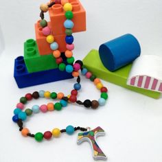 a necklace that has beads on it and a toy boat in the background with other items