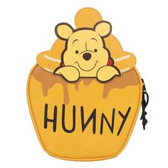 a winnie the pooh lunch bag that is yellow with black writing on it and has a brown bear sticking out of it