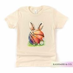 "Kids will love this \"EASTER BASKETBALL BUNNY\" youth short sleeve tee. This lightweight side-seamed shirt maximizes comfort all day long.  Easter Basketball Bunny Kids Shirt, Funny Easter Sports Tee, Kids Sports Gift, Bunny Player TShirt, Game Day Tee, Ball Player, Kids Gift 🌟100% Airlume combed and ringspun cotton (fiber content may vary for different colors) 🌟Light fabric (4.2 oz/yd² (142 g/m 🌟Retail fit RETURNS: All products are made-to-order and because of the nature of these items, all sales are final unless they arrive damaged or defective. CARE INSTRUCTIONS Turn Inside Out. Machine wash: cold (max 30C or 90F); Non-chlorine: bleach as needed; Tumble dry: low heat; Iron, steam or dry: medium heat; Do not dryclean. PLEASE SEE THE SIZING CHARTS for the measurements, and please cons Basketball T-shirt With Sublimation Print, White Short Sleeve Basketball T-shirt, Spring Sports T-shirt Pre-shrunk, Playful Sports T-shirt For Summer, White Short Sleeve T-shirt For Basketball, Fun Sports Short Sleeve T-shirt, Fun Sports T-shirt With Short Sleeves, Fun Sports T-shirt Short Sleeve, Spring Graphic Print T-shirt For Sports Events