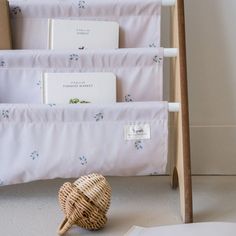 a stack of books sitting on top of a white floor next to a wooden ladder