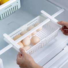 an open refrigerator with eggs in it and someone grabbing one from the fridge door to grab something out