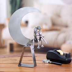 a small metal figurine sitting on top of a wooden table