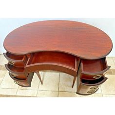 an oval shaped desk with drawers on the bottom and one section open to reveal a drawer