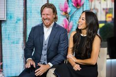 a man and woman sitting next to each other in front of a tv screen smiling