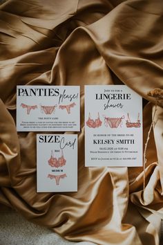 the wedding stationery is laid out on top of the brown satin sheeted bed