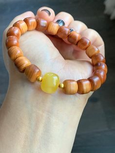 "All sales are FINAL and please ask questions before buying. Up for sale is a BRAND NEW natural YaBai Thuja Wood Beads, large \"Beewax\" fossilized tree resin drum bead, and pure 24K yellow gold beads beaded bracelet. The bracelet features natural and genuine Thuja wood or YaBai (崖柏木) beads. Thuja belongs to the cypress family. The wood has a natural organic fragrance that is similar to a pine tree. The beads are cut into tall drum beads. They are light weight and have super smooth and fine texture. It has a warm brown color with natural wood grains. The focal bead is a large and aged fossilized \"Beewax\" (蜜蜡) tree resin bead. It is cut into a large drum bead. It has extremely smooth and fine texture and semi-translucent. A very nice quality piece. It is 100% natural and genuine without a Resin Beads, Focal Bead, Pine Tree, Natural Organic, Gold Beads, Wood Beads, Beaded Bracelet, Drums, Jewelry Bracelets