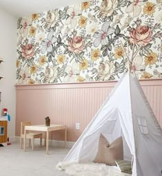 a child's playroom with a teepee tent in the corner and floral wallpaper on the walls