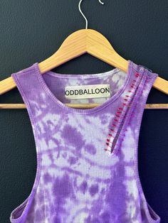 Our hand dyed tank top lets you stand out for your special event, night out, party, or music festival. Highlighted in Purple, the tank includes safety pin detail with a special cut out to the left shoulder. All safety pins were placed specifically for a comfortable wear, avoided contact with the skin. Size: SMALL Wash: Handwash or Gentle Cycle on cold setting + AIR DRY. (to preserve the quality of product.) Fabric Ornamentation, Fitted Purple Crop Top For Festival, Hand Dyed Acid Wash T-shirt For Festivals, Bleached Tie-dye Tops For Festival, Dance Hoodies, Rave Party Outfit, Summer Festival Tie-dye Crop Top, Edm Concert, Rave T-shirts & Tank Tops