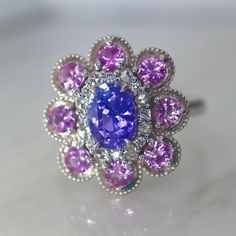 Lavender Sapphire Halo Ring I created with flawless precision cut unheated vivid Lavender sapphires and unheated pink sapphire. This ring's color combo is inspired by the paintings of lilacs by Claude Monet. The inner halo is made of both rose-cut and brilliant cut diamonds. The two kinds of diamonds sparkles so differently. The rose cut looks like the fresh morning dew on the flower petal, and the brilliant cut diamonds are the beautiful morning sunshine. I altered the design to have round edge Gia Certified Pink Sapphire Anniversary Ring, Gia Certified Pink Sapphire Ring, Gia Certified Pink Sapphire Ring For Anniversary, Elegant Purple Multi-stone Sapphire Ring, Pink Sapphire Ring In White Gold With Halo Setting, White Gold Pink Sapphire Ring With Halo Setting, Gia Certified Round Cut Pink Sapphire Ring, Formal Pink Multi-stone Sapphire Ring, Heirloom Multi-stone Purple Amethyst Ring