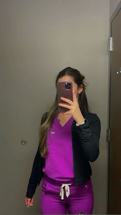 a woman is taking a selfie in the mirror with her cell phone and wearing purple pants