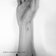 a person's hand with a small tattoo on the wrist and an anchor in the middle