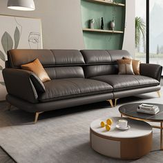 a modern living room with leather furniture and large windows overlooking the mountains in the distance