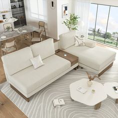 a living room filled with white furniture and lots of windows overlooking the ocean in front of it