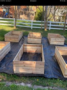 several wooden boxes sitting on top of a tarp in the middle of a yard