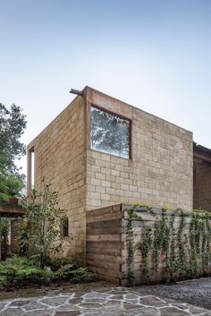 the house is made out of bricks and has a stone walkway leading up to it