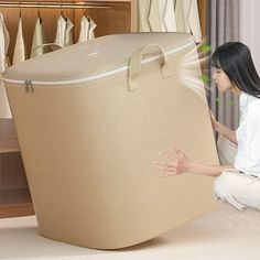 a woman kneeling on the ground next to a large piece of luggage in front of a closet