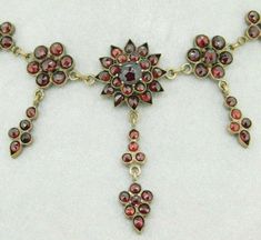 "All of our jewelry is guaranteed authentic by our Graduate Gemologist of the Gemological Institute of America (GIA). Genuine Natural Bohemian Garnet Necklace (#J320) Victorian gilt brass Bohemian garnet necklace with rose cut garnets. There are five rosettes each with a drop. The garnets range from 3mm to 6mm. The length of the necklace is 16 5/8\" long, and from clasp to center piece is 8 1/8\" long. The center drop is 1 7/8\" or 50mm long. The necklace weighs 9.3 dwt., and the piece dates fro Vintage Garnet Gemstone Necklace, Ornate Filigree Garnet Jewelry, Antique Garnet Pendant Necklace, Bohemian Garnet Necklace, Faceted Garnet Red Necklace, Natural Bohemian, Sterling Silver Flatware, Silver Flatware, Garnet Necklace