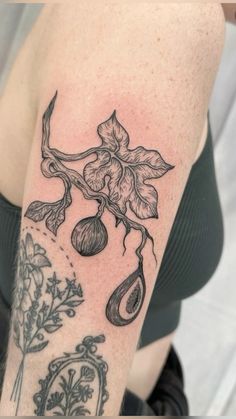 a woman's arm with tattoos on it and flowers in the middle of her arm