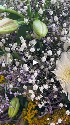 a bunch of flowers that are in some kind of vase on a table with white and yellow flowers