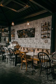 a restaurant with wooden tables and chairs in front of a large wallpapered wall