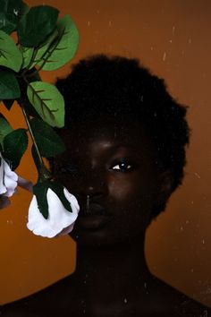 a woman with black skin and white flowers in her hair