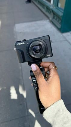 a person holding up a camera on the street