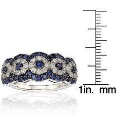 The ring is pave set with 1.03 carats of natural blue sapphires, 1.04 carats of created white sapphires, and a .02 carat fancy brown diamond. This Suzy Levian gallery ring features her unique logo on the inside of the band. Features: Anniversary band Multi-circle design Gold Plated sterling silver High polish Band width is 3-4 mm Ring measures 9 mm long x 23 mm wide x 6 mm high Gemstones: Created white and natural blue sapphires Round-cut Pave setting Total gemstone weight 2.08 carats Diamond: 1 Gemstone Brooch, Diamond Anniversary Bands, Cubic Zirconia Bracelet, Cubic Zirconia Necklace, Cubic Zirconia Jewelry, Jewelry Rings Diamond, Cubic Zirconia Earrings, Diamond Anniversary, Pave Setting