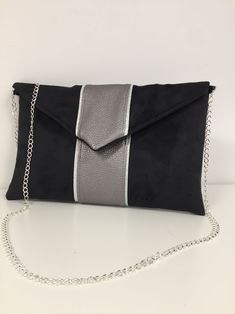 Black and gray iridescent evening clutch bag, wedding clutch bag envelope shape customizable, small handbag with flap and removable chain for a shoulder or shoulder strap, very trendy for your outings, a wedding, bridesmaids or a ceremony. This elegant pouch will easily contain your essential phone, makeup, keys, glasses, papers ... The pouch is made of thick suedette, very velvety touch, suede effect, with a strip of iridescent gray vegetable leatherette hemmed with a silver border. 2 options a Chic Silver Clutch Shoulder Bag, Silver Shoulder Bag With Removable Pouch For Party, Silver Party Shoulder Bag With Removable Pouch, Modern Silver Clutch Bag, Elegant Silver Shoulder Bag With Magnetic Closure, Silver Clutch With Magnetic Closure, Silver Clutch Bag For Night Out, Modern Shoulder Bag Clutch For Party, Silver Chic Clutch For Gift