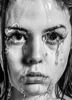 black and white photograph of a woman with water on her face