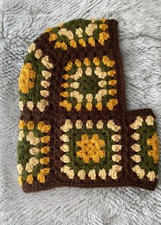 two crocheted potholders sitting on top of a white blanket