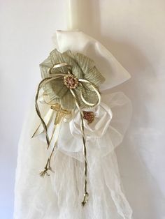 a close up of a flower on a white cloth with some beads and leaves attached to it