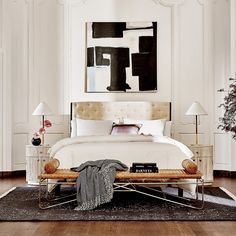 a white bed sitting on top of a hard wood floor next to a wooden table