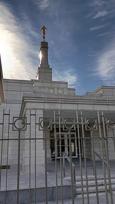 a building with a statue on top of it's roof and gated entrance